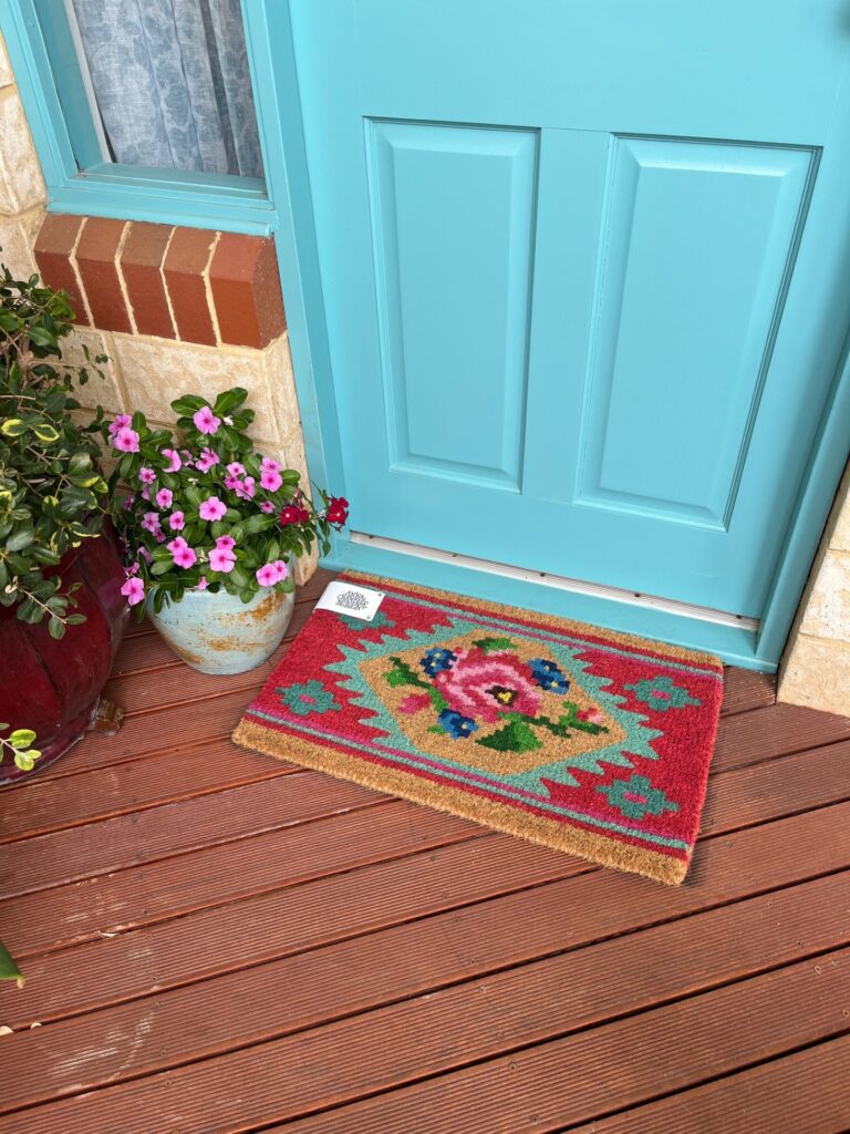 a doormat on a porch with roses